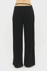Black Emilia pants from findmenowthelabel, showing a close-up of the tailored fit and fabric texture.