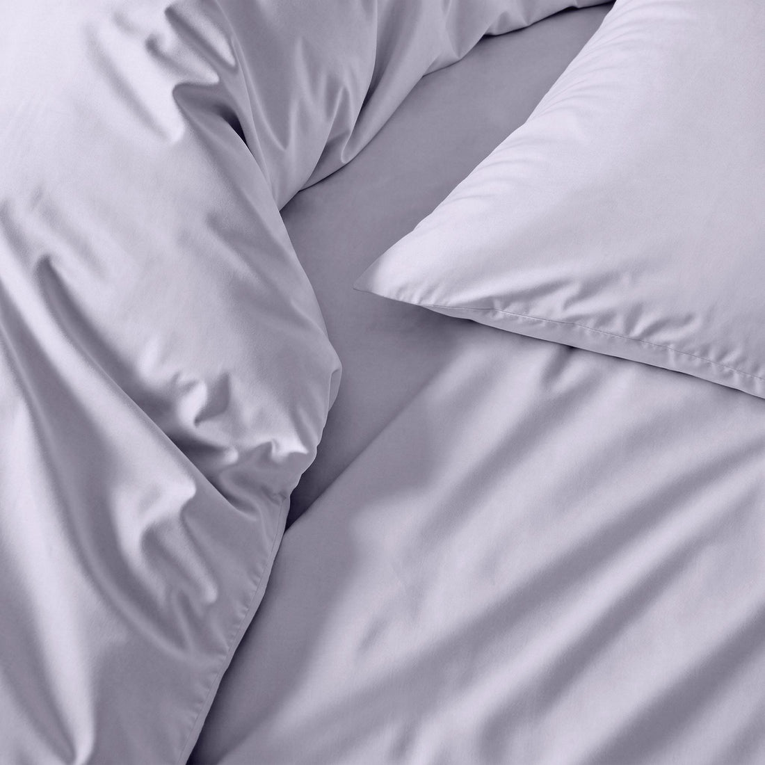 Cream-colored Luxe Australian Sateen Sheet Set by Italic on a neatly made bed with soft, smooth sheets and pillowcases.