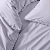 Cream-colored Luxe Australian Sateen Sheet Set by Italic on a neatly made bed with soft, smooth sheets and pillowcases.