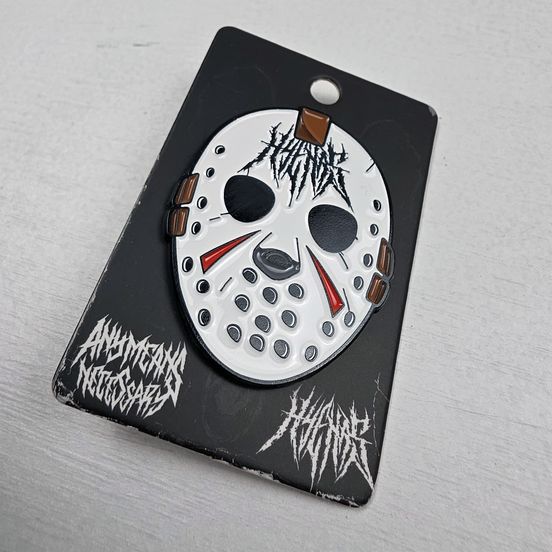 Close-up of a Hockey Hyena enamel pin from Any Means Necessary Clothing, featuring a detailed hyena design on a metal pin.