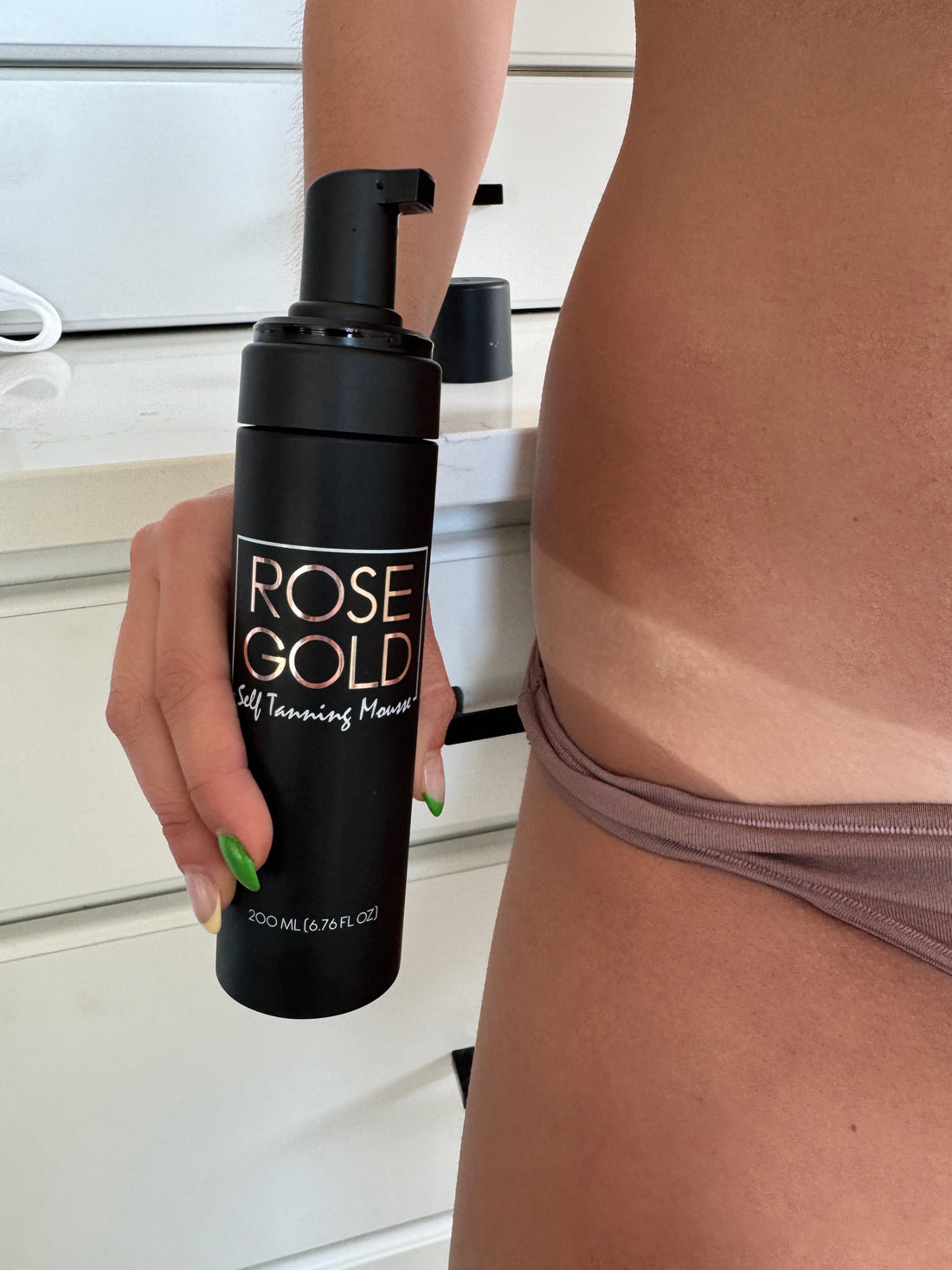 Travel size Rose Gold Sunless Self Tanning Mousse bottle, perfect for on-the-go bronze tanning, with a sleek design and pump dispenser.