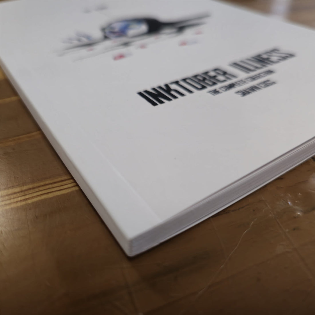 Inktober Illness Softback Book by Any Means Necessary Clothing, featuring the complete collection of illustrated ink artwork.