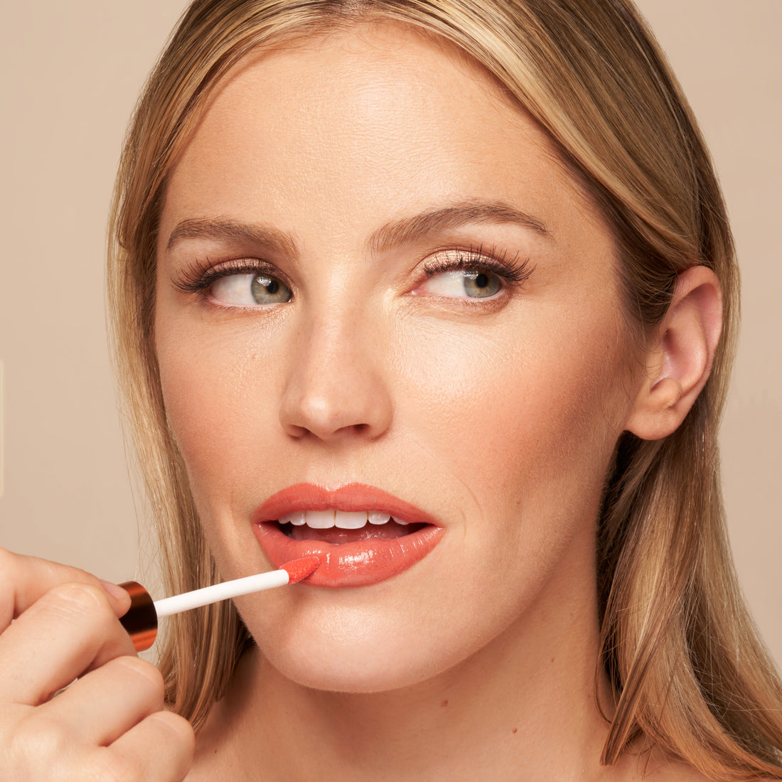YENSA Luxe Lip Nourishing Oil with hyaluronic and vitamin E, featuring a subtle coral lip oil in a sleek applicator tube.