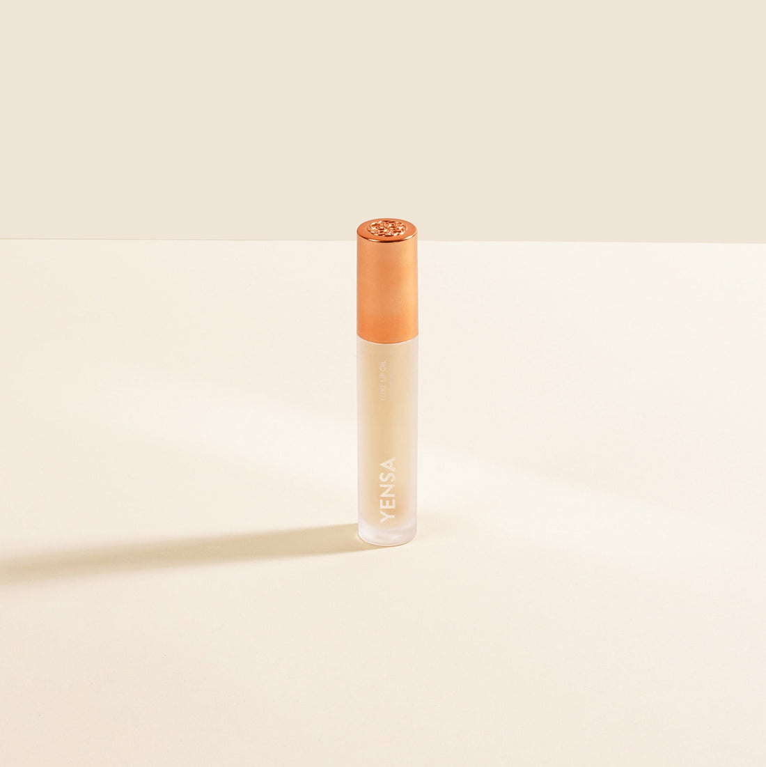 YENSA Luxe Lip Nourishing Oil with hyaluronic and vitamin E, clear lip oil bottle showing glossy finish and applicator tip.
