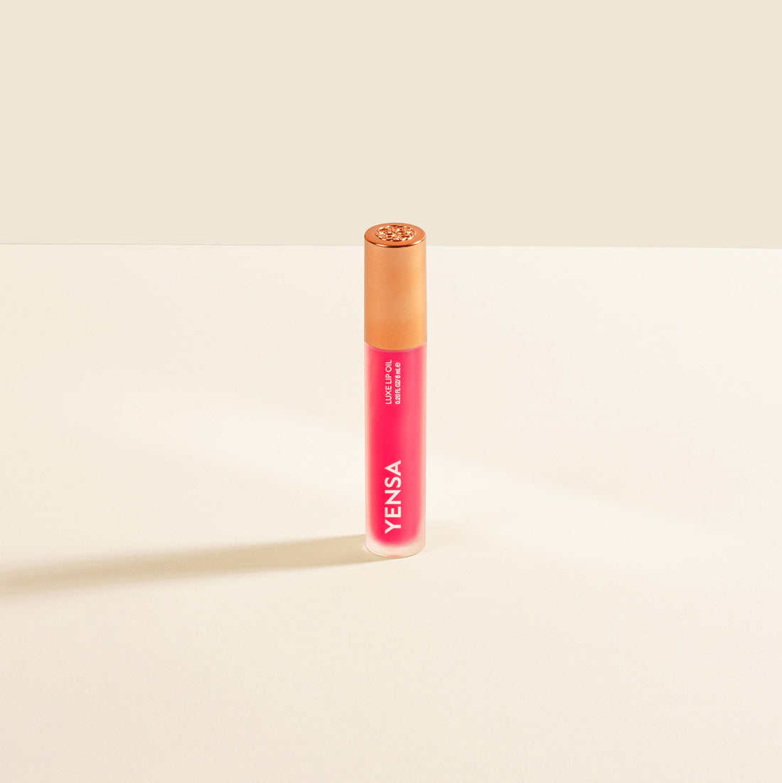 YENSA Luxe Lip Nourishing Oil with hyaluronic and vitamin E, pink shiny lip oil in a sleek tube.
