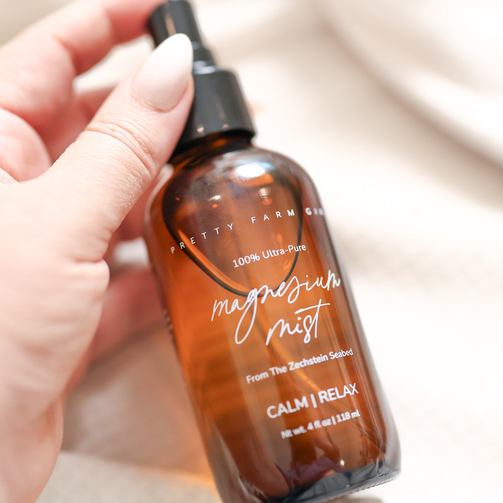 Pretty Farm Girl magnesium mist body spray toner with a spray bottle and fresh botanical background.