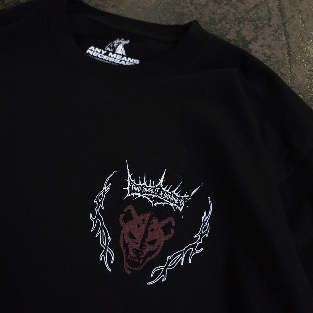 Close-up of black Mantra T-Shirt by Any Means Necessary Clothing, showing the fabric and neckline detail.