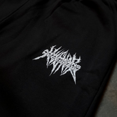 Close-up of black Mantra Sweatpants by Any Means Necessary Clothing, showing the fabric texture and waistband detail.