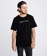 Men wearing black cotton T-shirt by Goal Five, casual lifestyle clothing, front view showing classic fit and soft fabric.