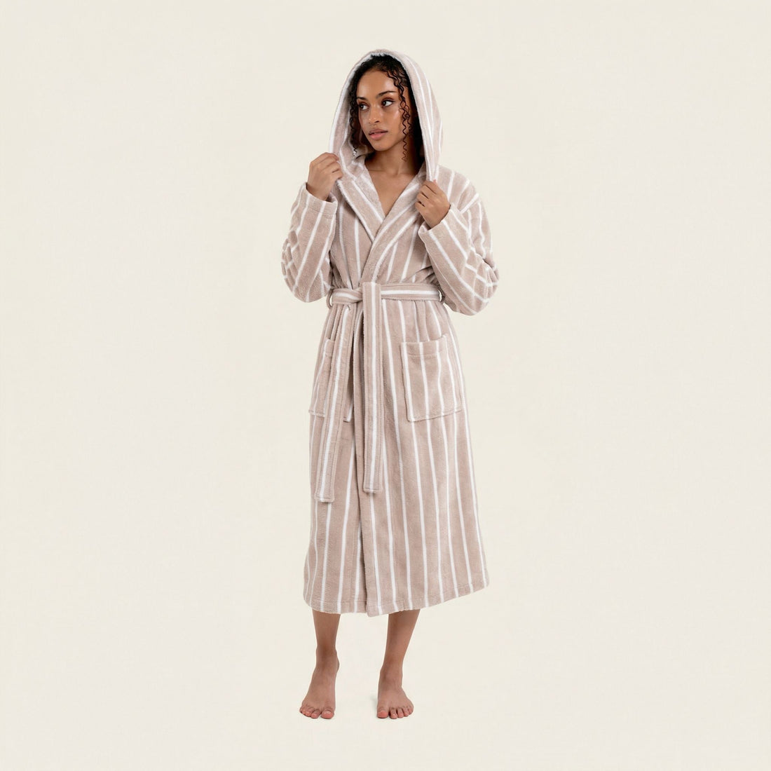 Unisex Ultraplush Australian Cotton Bathrobe by Italic, soft white plush fabric with a shawl collar and belt, hanging on a wooden hook.