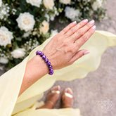 Siberian Charoite bracelet from Conscious Items featuring polished purple stones on an elastic band, close-up view.