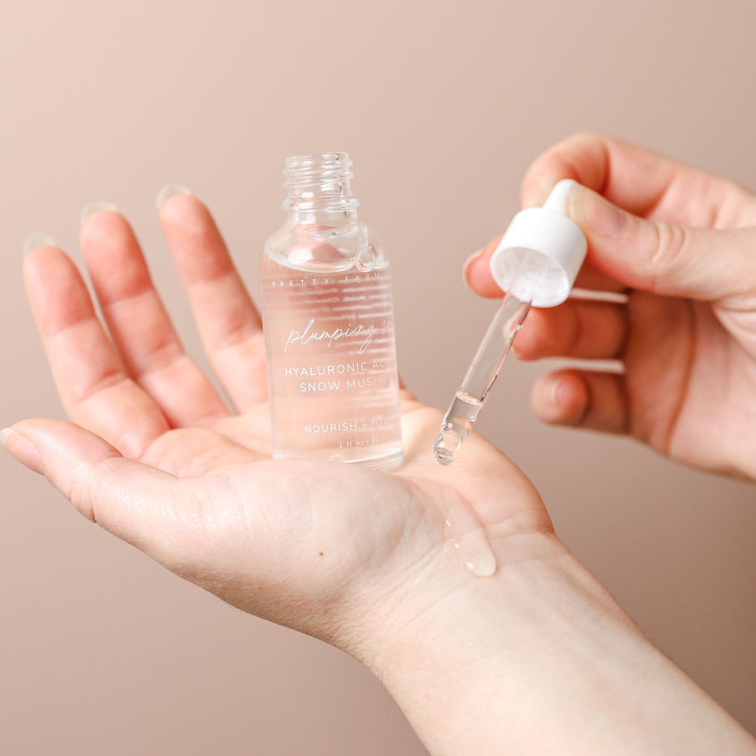 Pretty Farm Girl Hyaluronic Plumping Face Serum with Vitamin B5 and Snow Mushroom, shown on hand.