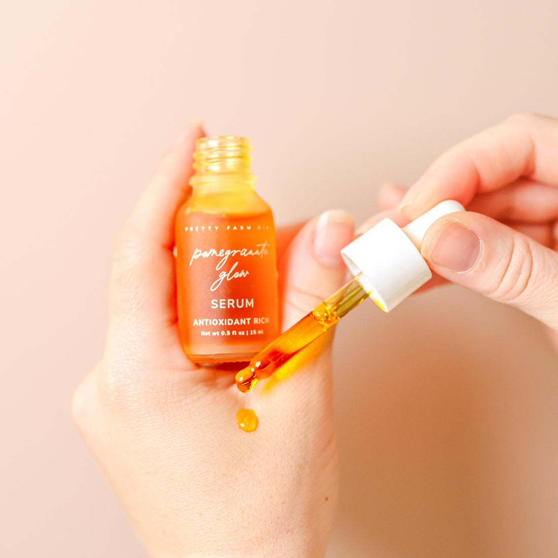 Pretty Farm Girl Pomegranate Glow Face Serum in a 0.5oz bottle, showcasing natural skin protection ingredients with a vibrant label.