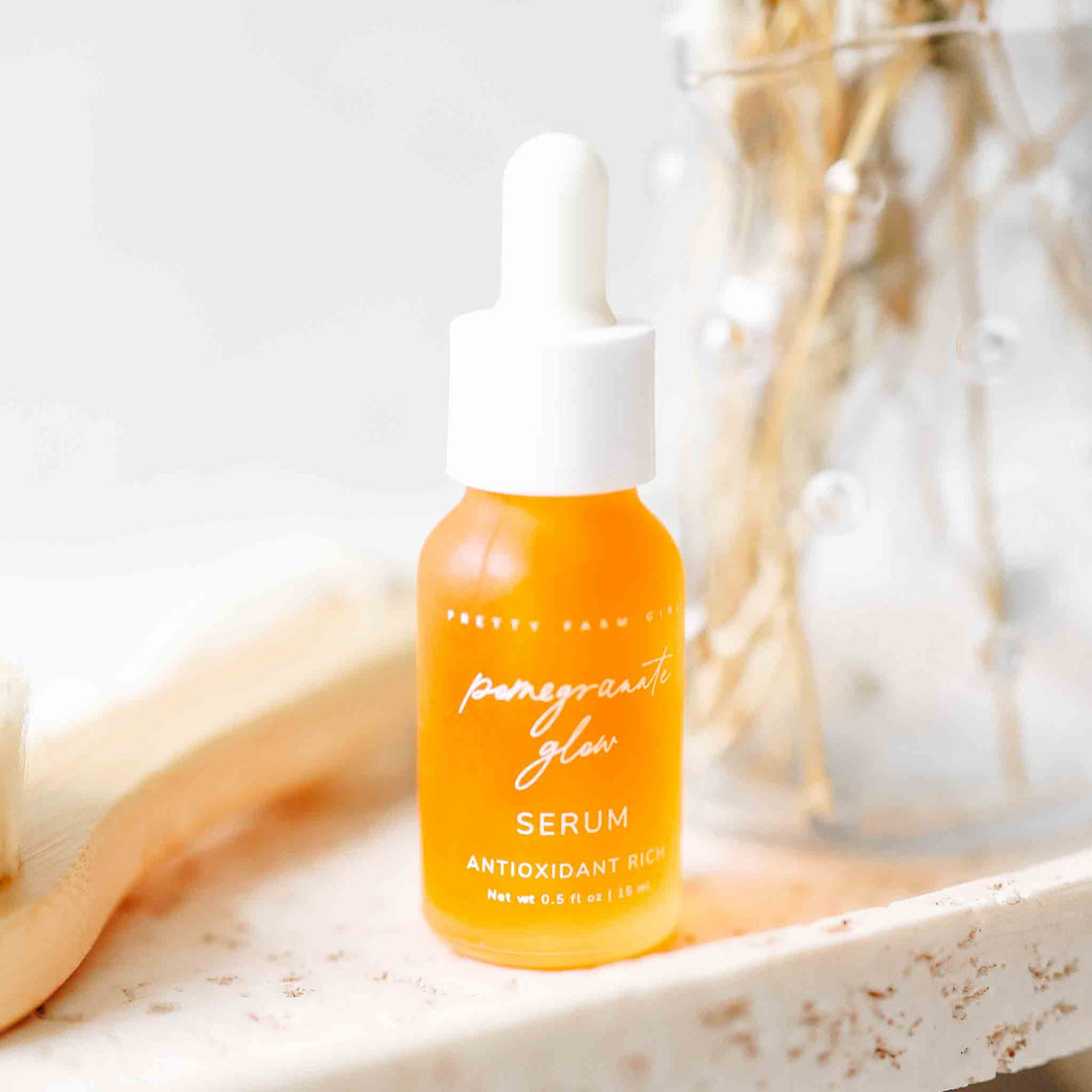 Pretty Farm Girl Pomegranate Glow Face Serum bottle with a glowing pomegranate illustration, natural skincare product for skin protection.