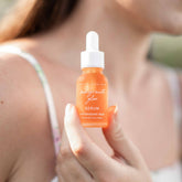 Pomegranate Glow face serum by Pretty Farm Girl in a clear dropper bottle, highlighting natural skin protection ingredients.