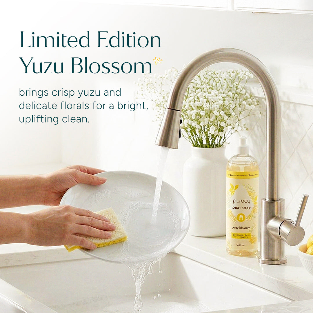 Puracy Yuzu dish soap in a clear bottle with a yellow label, showing a splash of water and fresh citrus fruits.