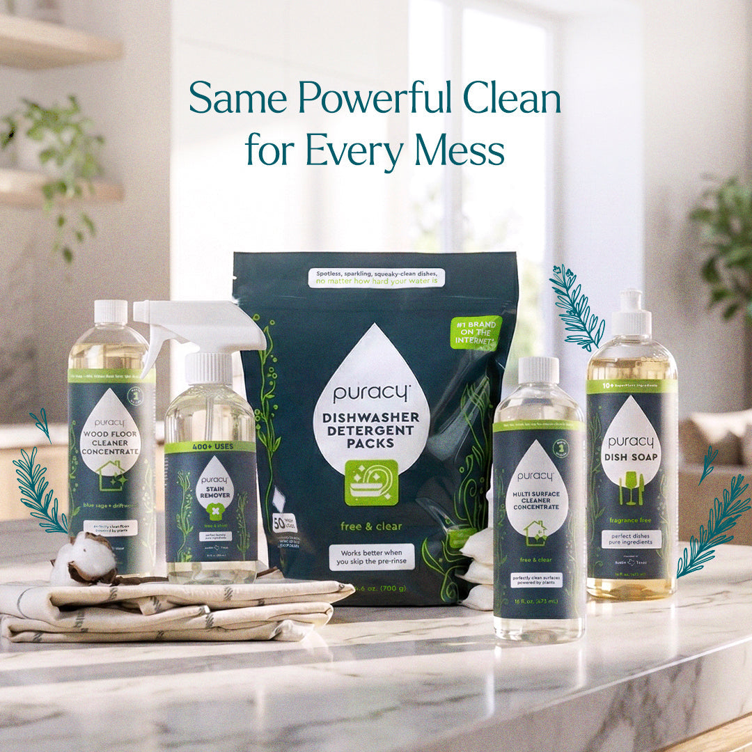 Puracy Everyday Multi-Surface Cleaner bottle and spray on a wooden floor, suitable for cleaning various surfaces in the home.