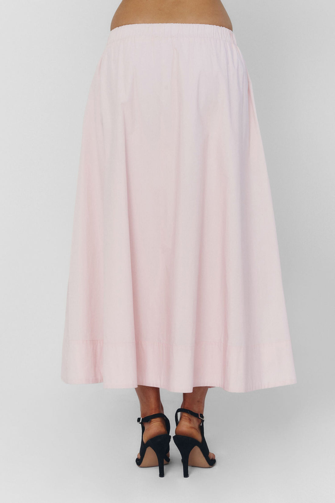 Findmenowthelabel UIARA pink skirt displayed on a hanger, showcasing its soft, baby pink fabric and stylish design.