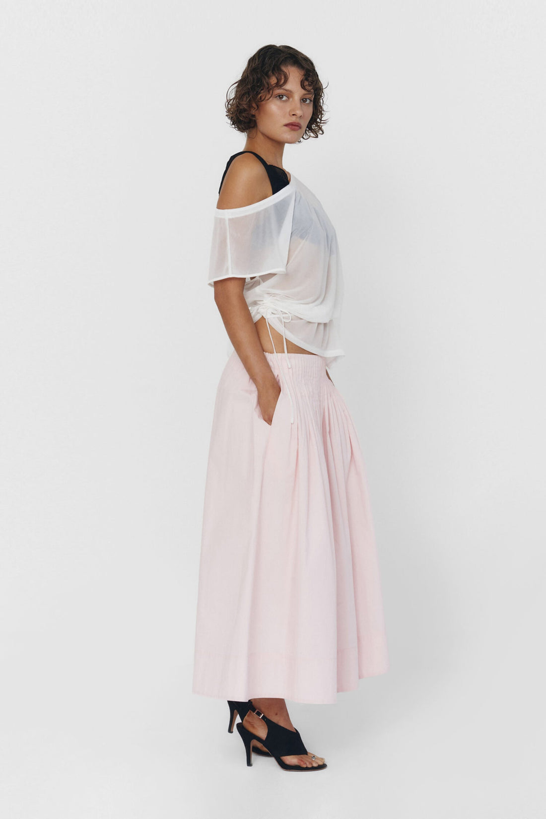 Findmenowthelabel UIARA pink skirt in baby pink fabric, shown on a hanger with a close-up of the soft, lightweight material.