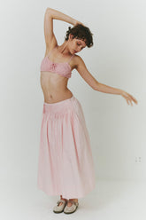 Findmenowthelabel UIARA baby pink skirt shown in a stylish, flowing design on a model in a fashion editorial shot.