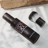 Rose Gold Sunless facial tanning mist in clear spray bottle with kabuki brush for natural, even sunless facial tanning.