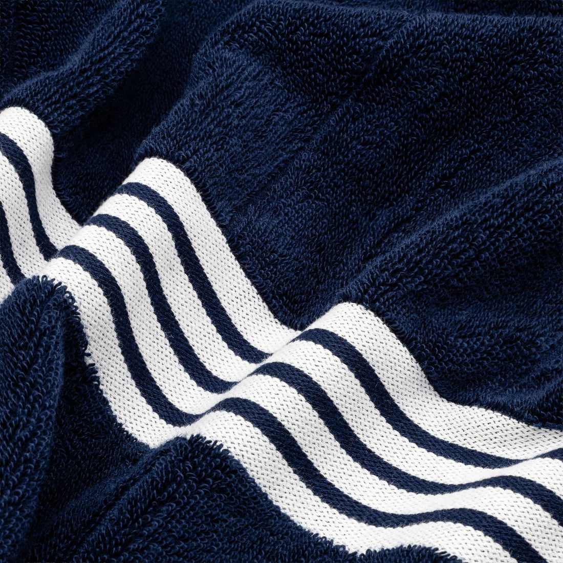 Soft Nautilus Australian Cotton Bath Towel by Italic with textured white fabric, displayed on a bathroom hook.