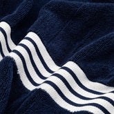 Soft Nautilus Australian Cotton Bath Towel by Italic with textured white fabric, displayed on a bathroom hook.