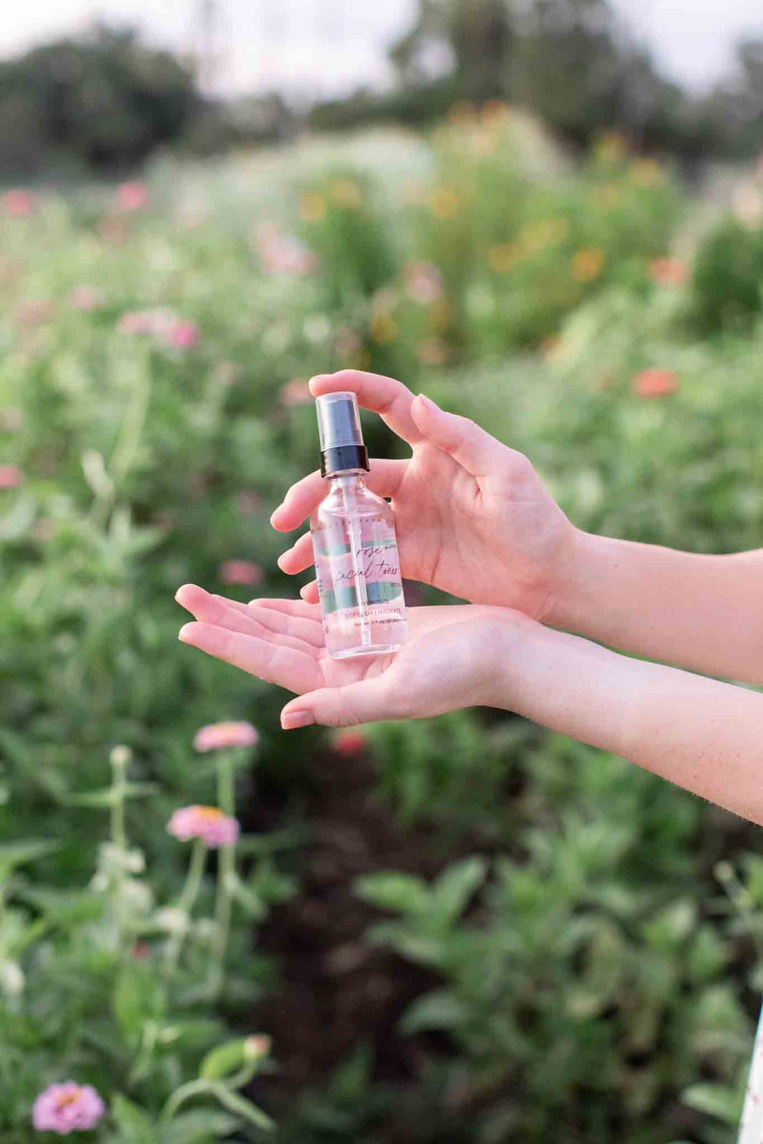 Organic Pure Rose Facial Toner bottle by Pretty Farm Girl, featuring a clear glass bottle with a rose-themed label and a spray nozzle.
