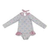 Baby girl long sleeves floral one-piece swimsuit by Mini Rodeo, featuring a bow and vibrant floral pattern.