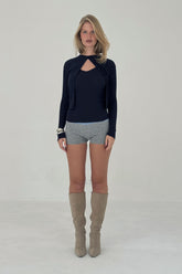 Navy ribbed knit cardigan by findmenowthelabel, showing close-up of textured knit fabric and button details.
