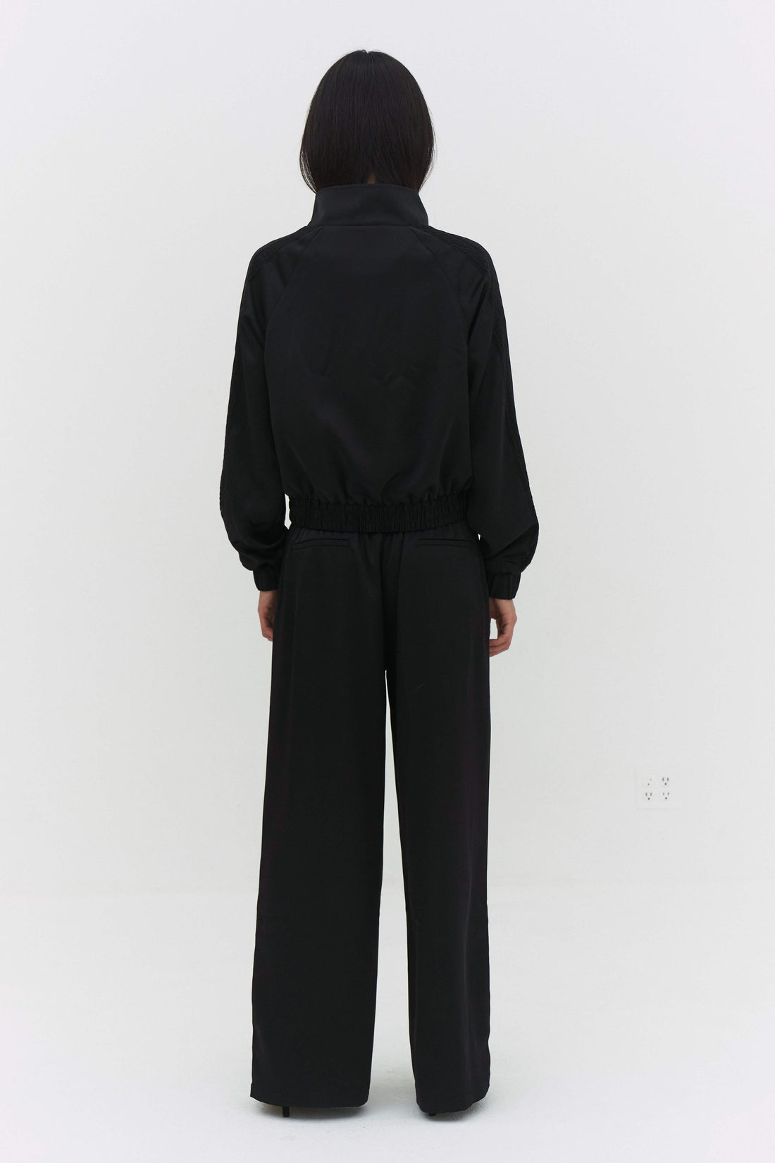 Black Leiseu track jacket by findmenowthelabel, featuring a sleek fit and sporty design on a mannequin.
