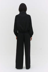 Black Leiseu track jacket by findmenowthelabel, featuring a sleek fit and sporty design on a mannequin.