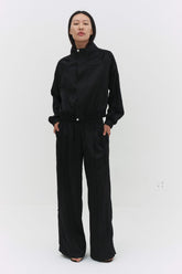 Black Leiseu track jacket by findmenowthelabel, featuring a sleek fit and sporty design, shown with front zipper and stand collar.