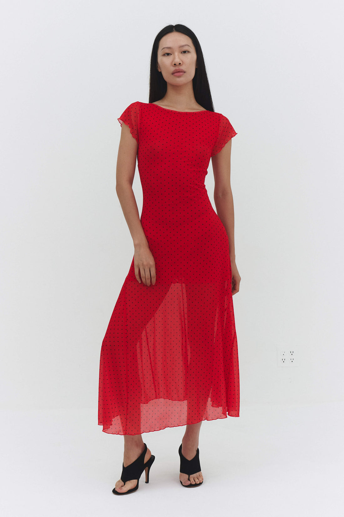 Red Valentia maxi dress by findmenowthelabel displayed on a model with flowing fabric and elegant design.