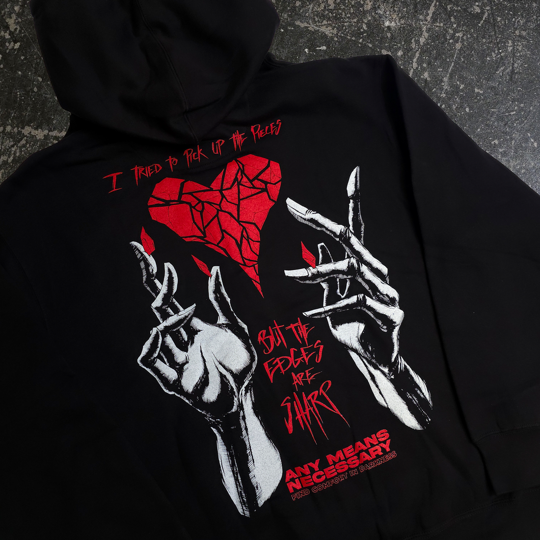 Back view of black Sharp Edges zip-up hoodie by Any Means Necessary Clothing, featuring sharp edge design details.