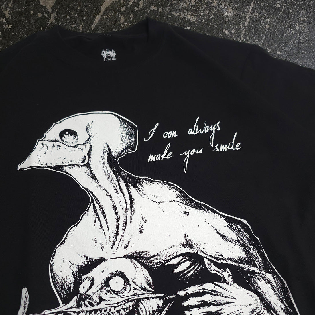 Black Always Smile T-Shirt from Any Means Necessary Clothing featuring a close-up of the smile graphic on front.