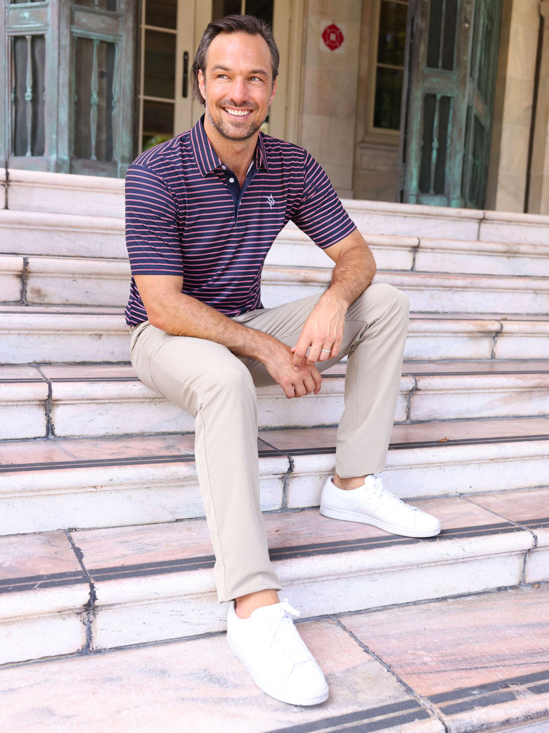 Navy striped White Water Life Striper Polo shirt displayed on a hanger, showcasing its casual, nautical-inspired design.