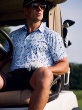 White Water Life Surfs Up Performance Polo showing a stylish polo shirt with surf-inspired design in a casual seaside setting