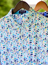 White Water Life Surfs Up Performance Polo hanging on a surfboard-shaped hanger, showcasing a stylish, breathable polo shirt for active wear.