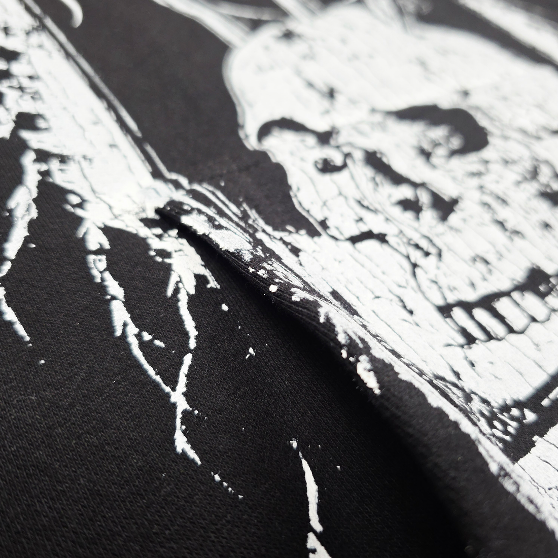 Close-up of Any Means Necessary Clothing Defeatist pullover hoodie showing the fabric texture and detailed design on the front.