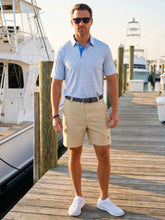 White Water Life Tuna Performance Polo in light blue and navy, shown worn casually outdoors by a dock.
