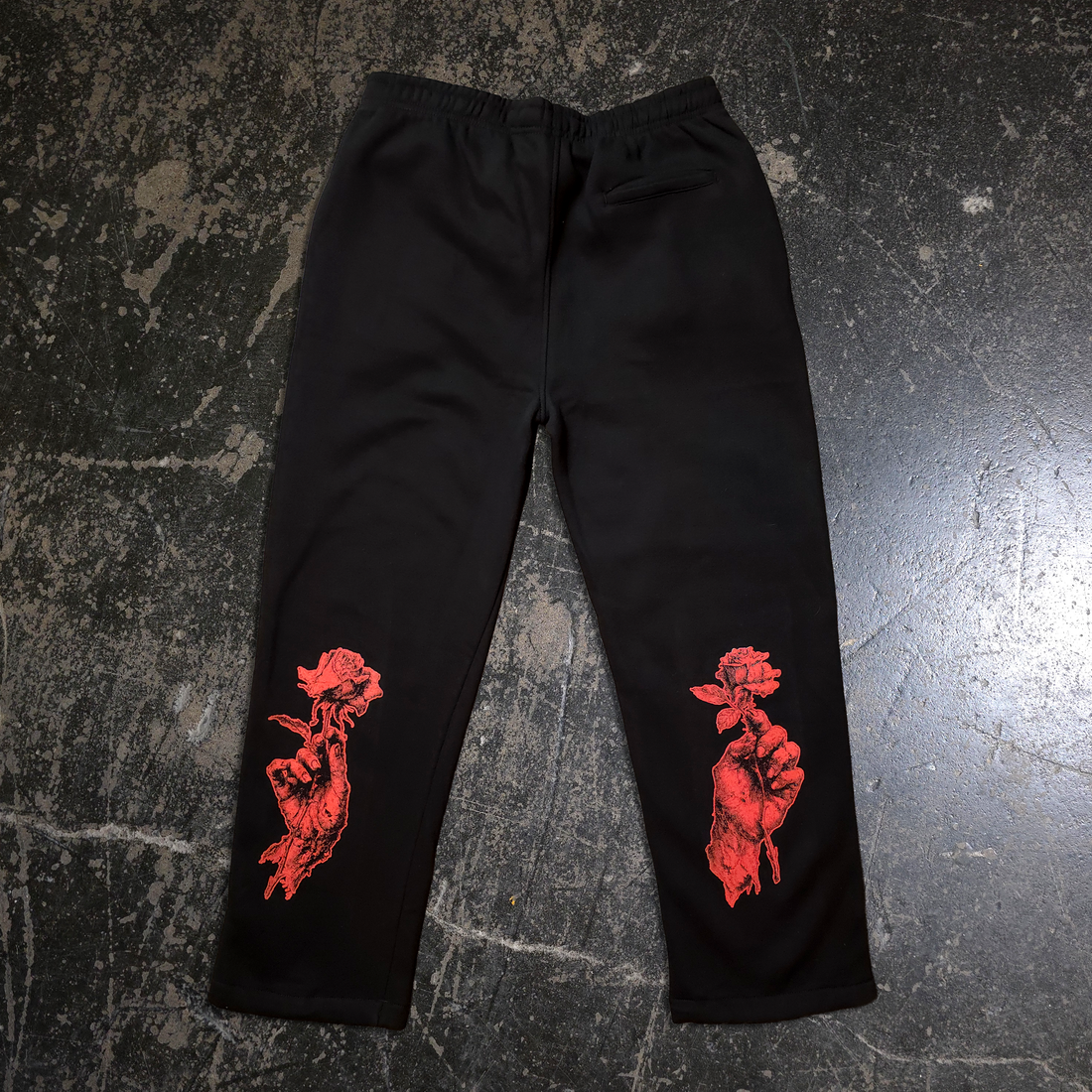 Black "When Death Comes" sweatpants from Any Means Necessary Clothing, showing the back view with logo and design details.