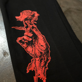 Black "When Death Comes" sweatpants by Any Means Necessary Clothing, close-up showing the fabric and design details.