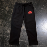 Black "When Death Comes" sweatpants by Any Means Necessary Clothing, front view showing casual fit and design details.