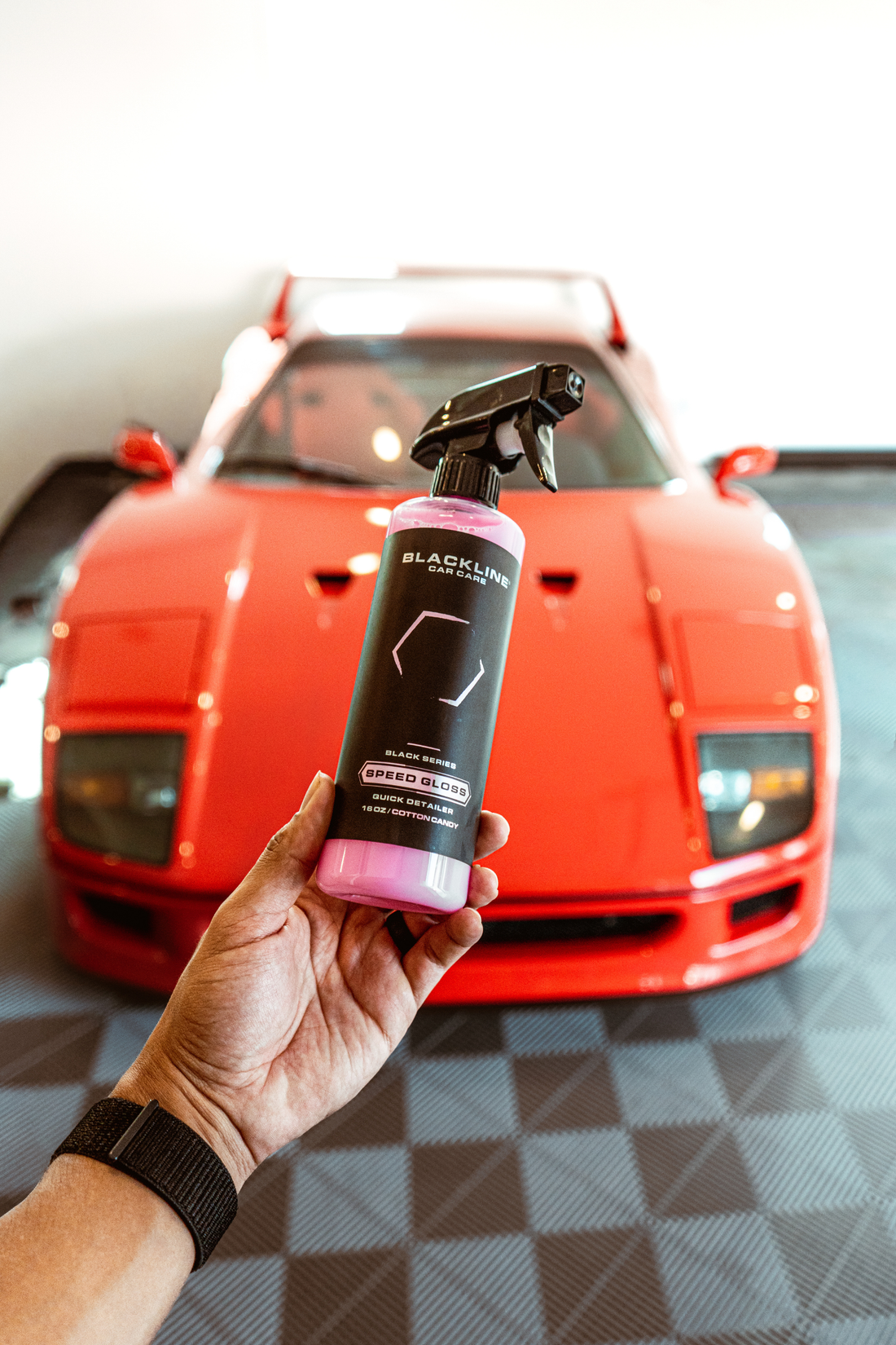 Blackline Car Care BLACKLINE® Speed Gloss Quick Detailer showing a sleek car surface with a spray bottle and shining finish.