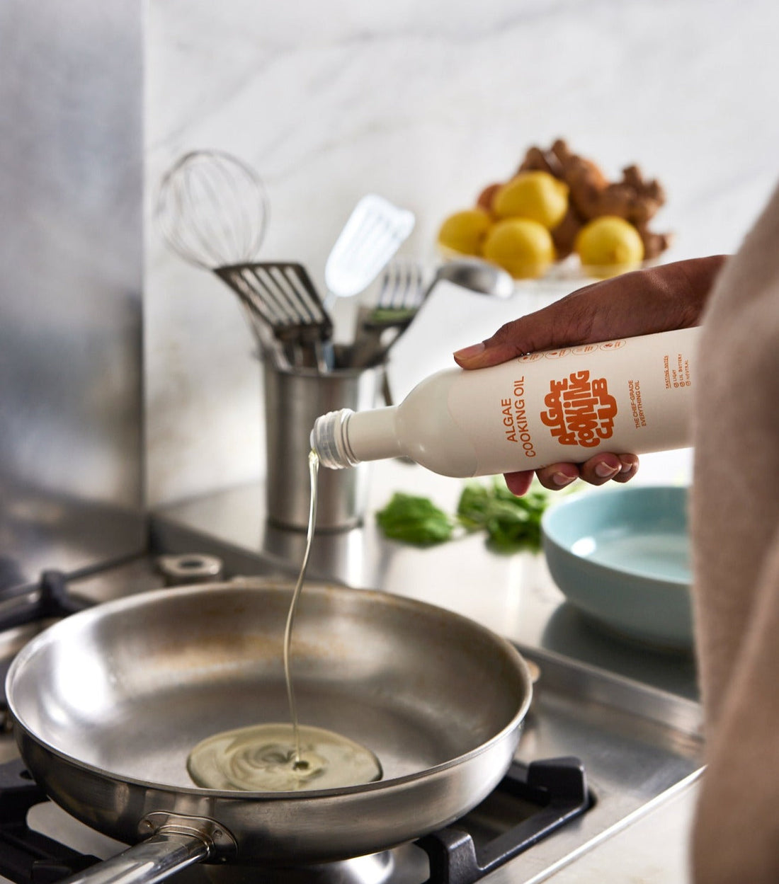 Bottle of Algae Cooking Oil from Algae Cooking Club, showing the label and clear plastic container with golden-colored oil.