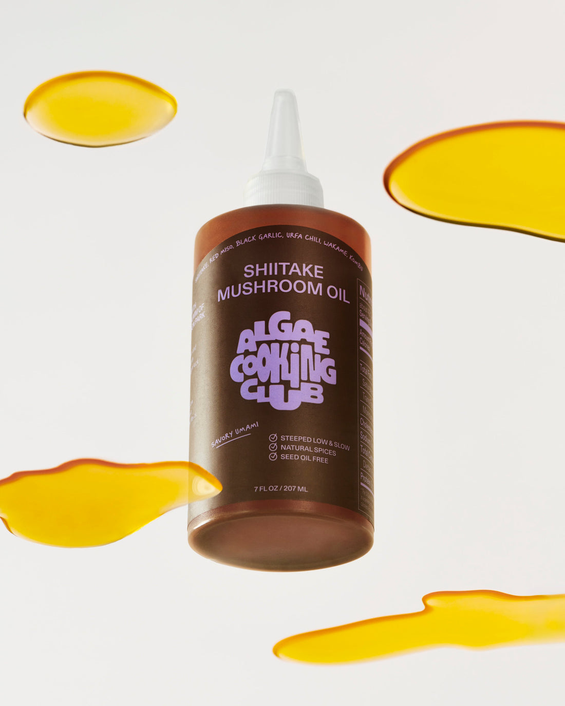 Bottle of mushroom-infused oil from Algae Cooking Club, showcasing clear glass container with dark mushroom-flavored oil.