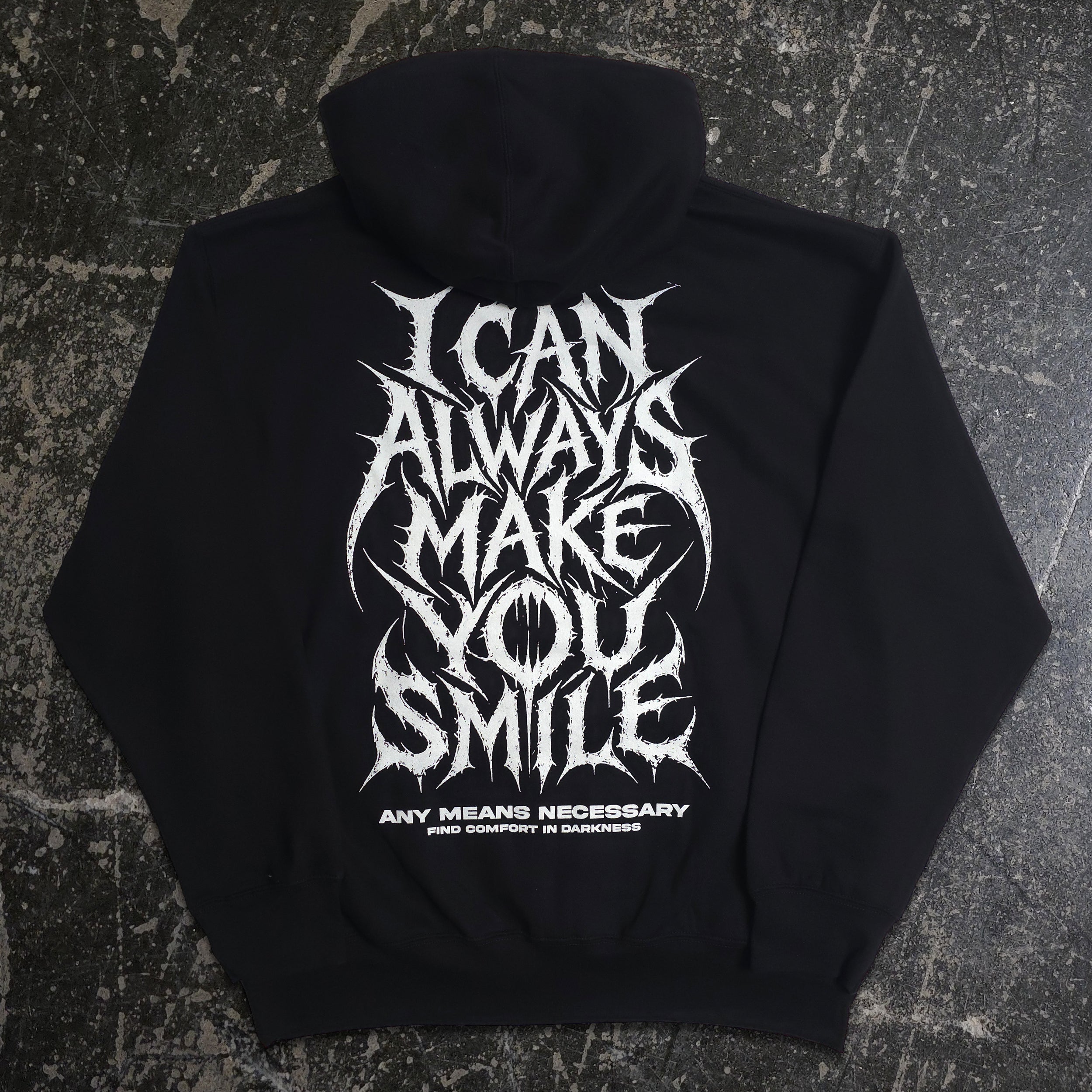 Back view of black Always Smile hoodie by Any Means Necessary Clothing, featuring a smiling face graphic on the back.