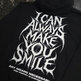 Black Always Smile Pullover Hoodie from Any Means Necessary Clothing, featuring a close-up of the smile graphic on the front.
