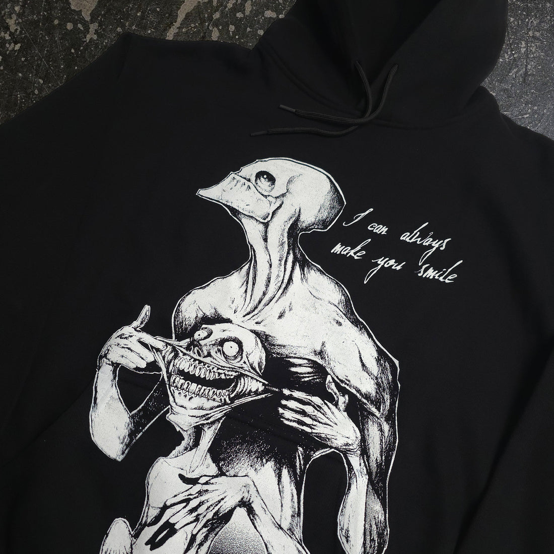 Black Always Smile Pullover Hoodie by Any Means Necessary Clothing, featuring a close-up of the smiling graphic on the front.